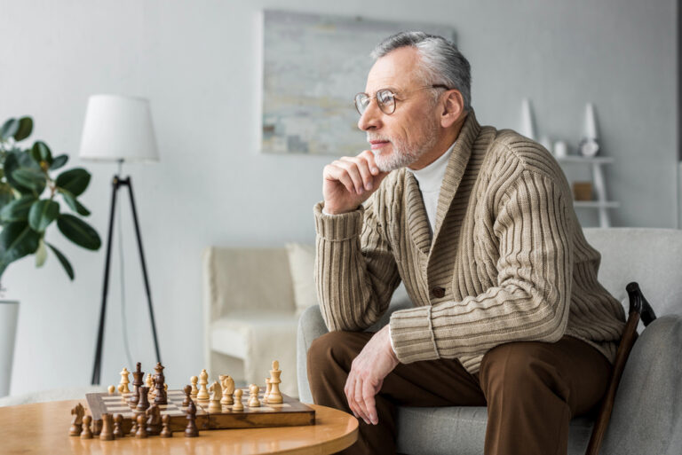 man thinking and playing chess