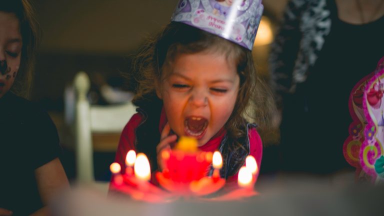 kid blowing out candle