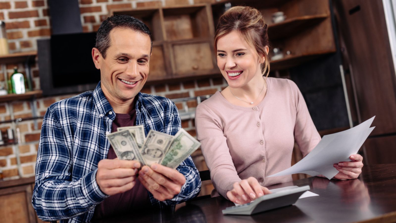 couple with money calculator finances happy kitchen