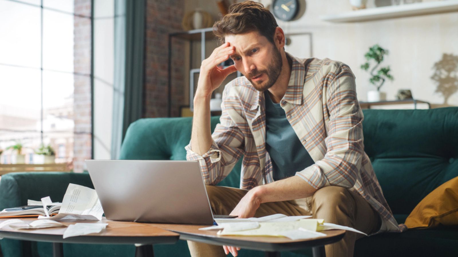 stressed man on laptop money confused
