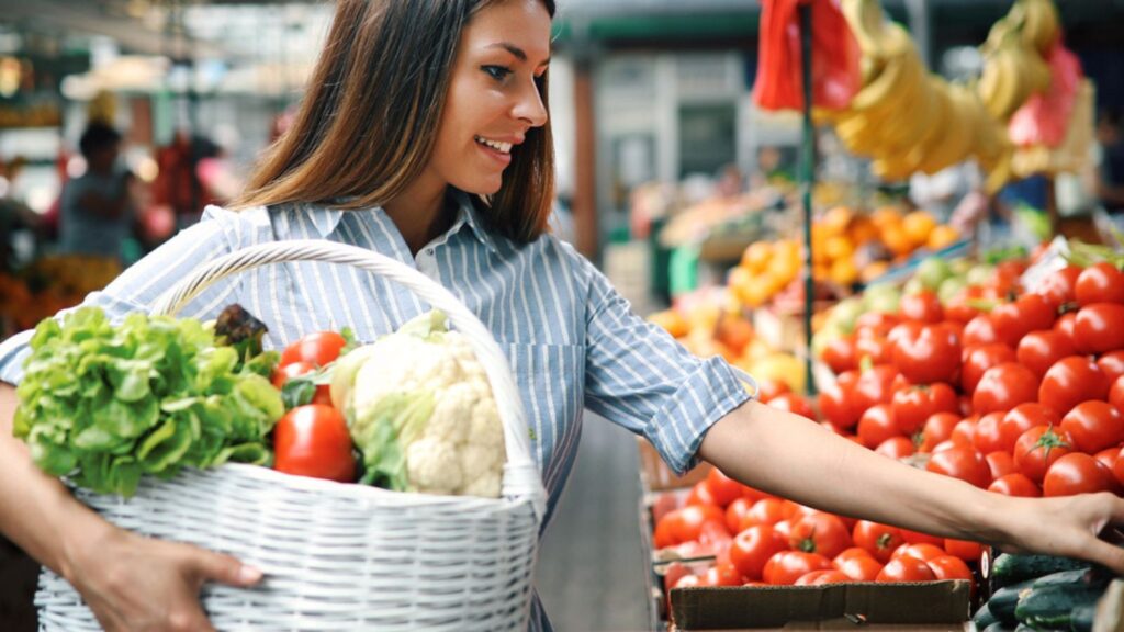 Woman at marketplace buying vegetables