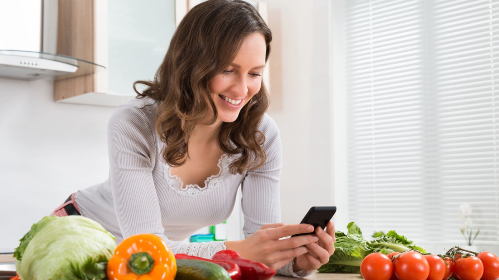 Woman Smiling While Using Mobile Phone