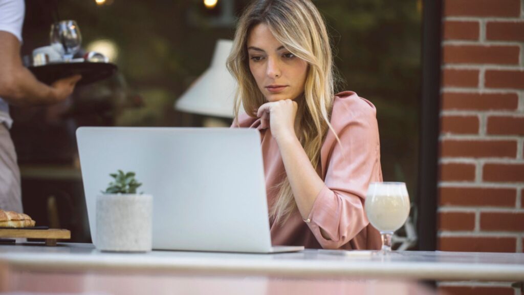 A Woman Reading on Laptop at Coffee Shop