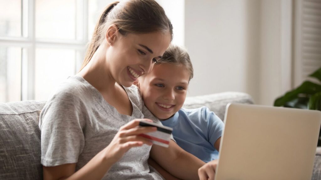 Mother and daughter using card paying money and buying online