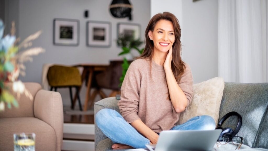 Shot of an attractive middle aged woman sitting on the sofa while using laptop