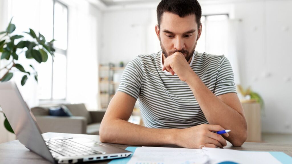 Stressed Man with papers document and laptop