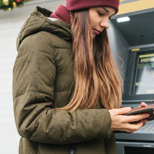 A young woman takes money from an ATM