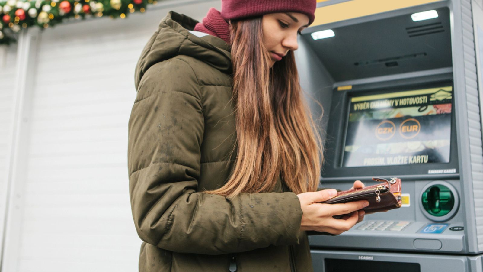 A young woman takes money from an ATM