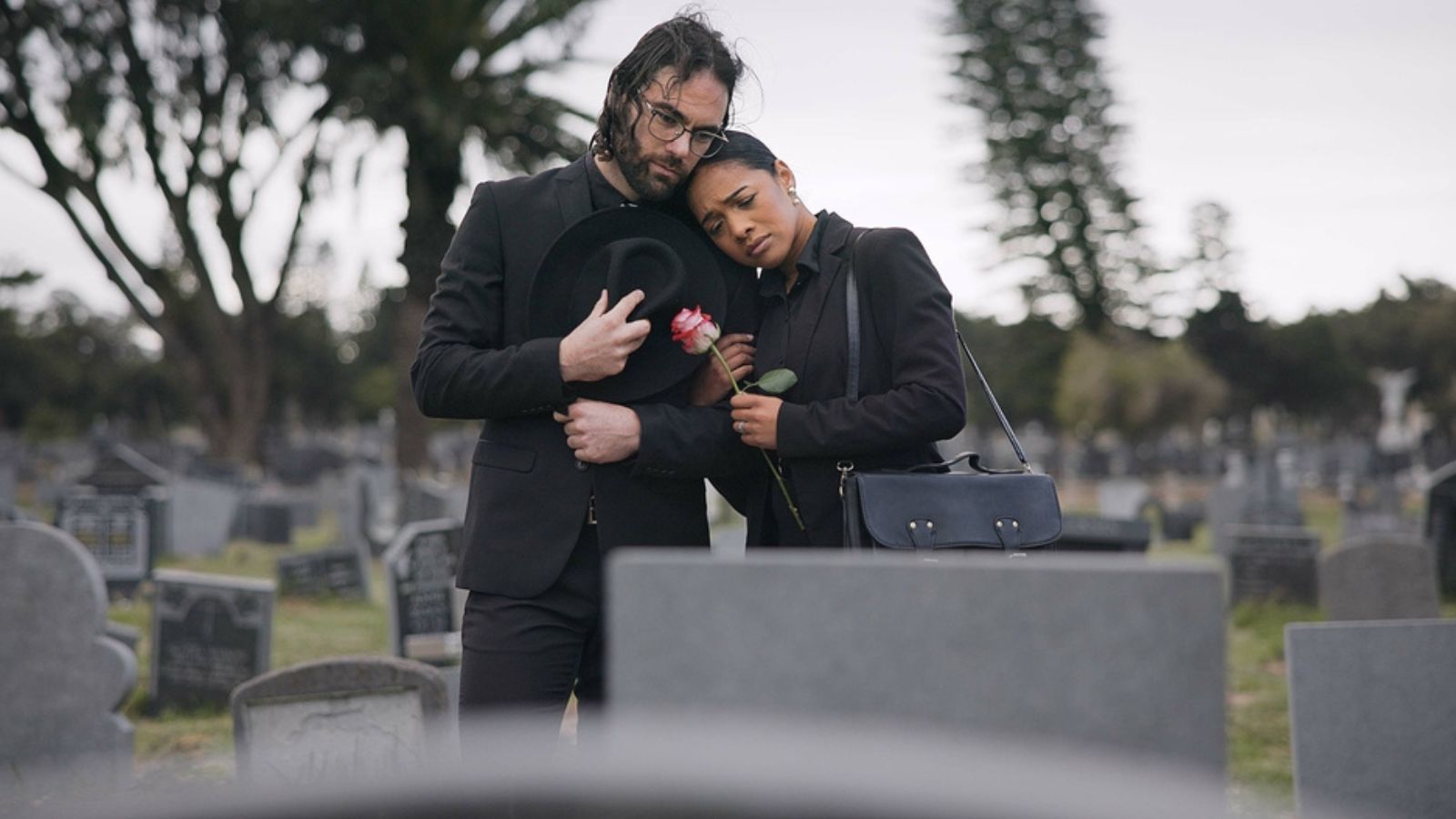 Couple, sad and mourning at tomb of graveyard, funeral cemetery