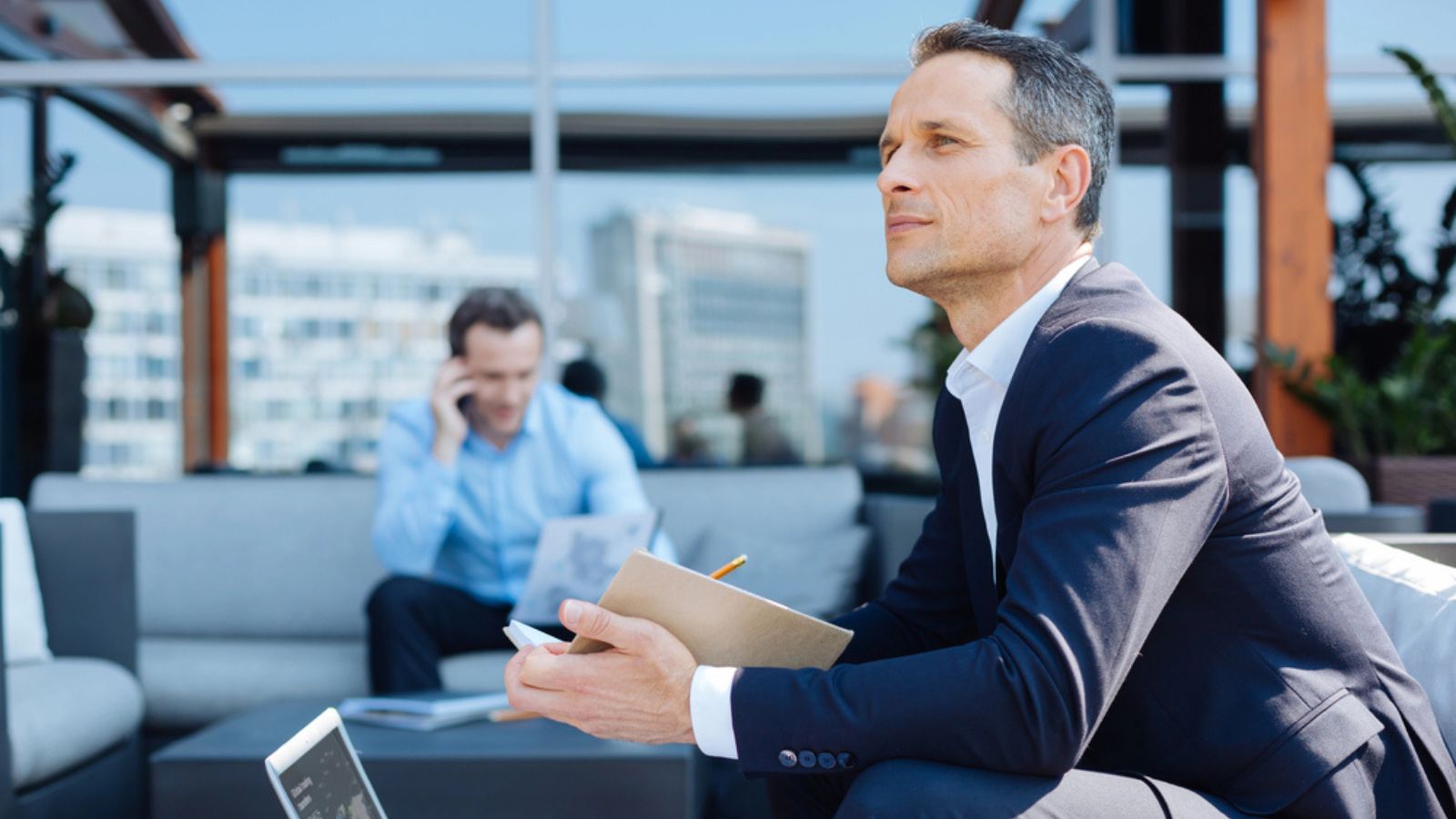 rich business man thinking taking notes notebook airport lounge thinking
